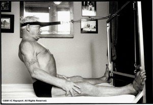 Joseph Pilates fazendo um de seus exercícios. Muitos aparelhos se assemelham ao dia de hoje.